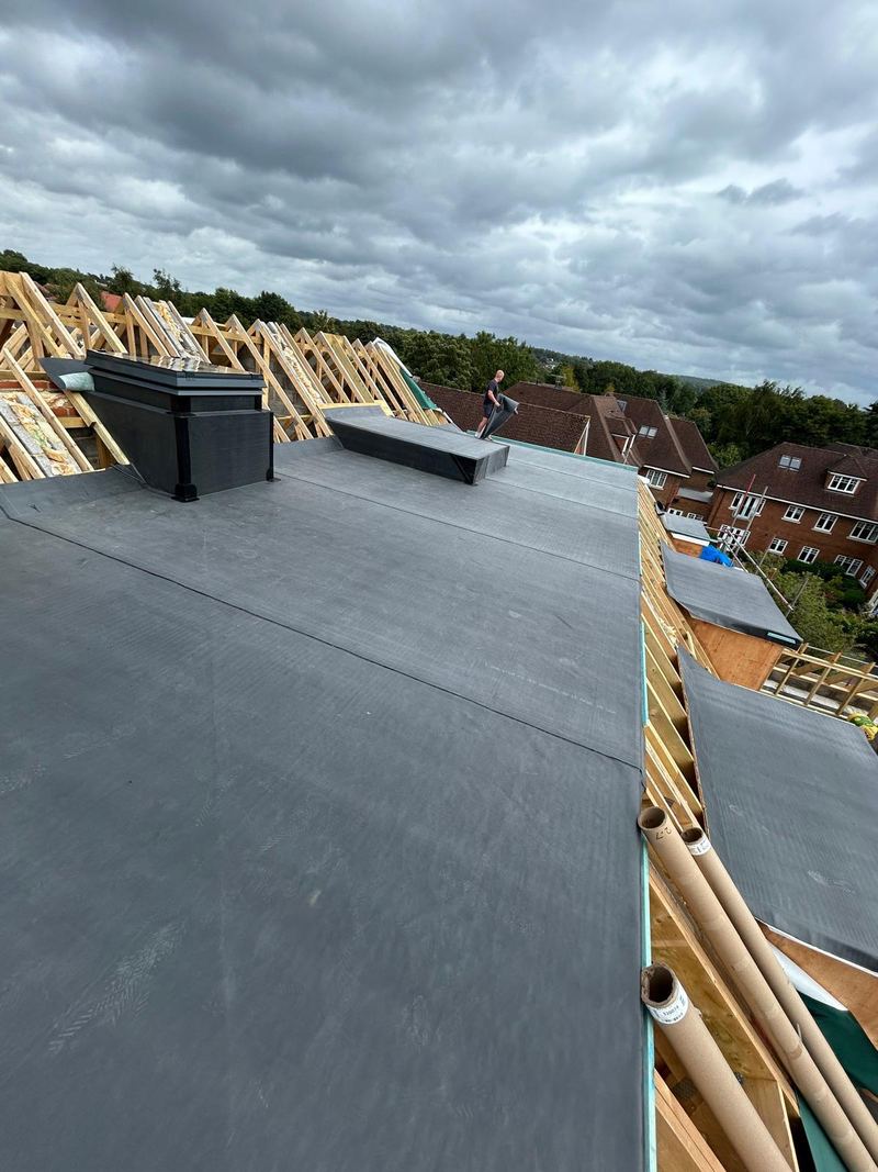 A large EPDM rubber flat roof, with the new timber roof structure alongside